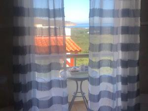 een kamer met een raam met een tafel en uitzicht op de oceaan bij Elia Studios in Palekastron