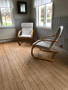 um quarto com duas cadeiras e duas janelas em Hagabergets Vandrarhem em Ullared