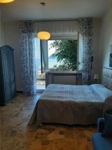 a bedroom with a bed and a large window at Residence Sole in Albenga