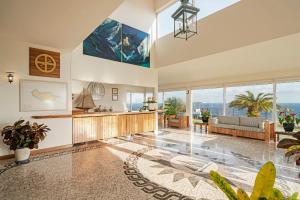 Albatroz Beach & Yacht Club في سانتا كروز: غرفة معيشة كبيرة مع نوافذ كبيرة وأريكة