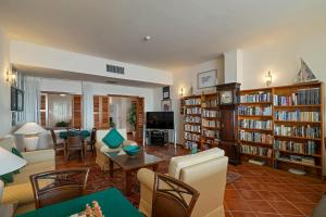 a living room filled with furniture and bookshelves at Albatroz Beach & Yacht Club in Santa Cruz