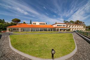 a building with an orange roof and a grass field at Albatroz Beach & Yacht Club in Santa Cruz