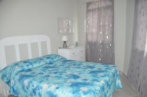 une chambre avec un lit recouvert d'une couette bleue dans l'établissement Caribe Apartament S&D el castillo dominicus Apartamento #9, à Bayahibe