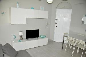 - un salon avec une télévision sur un meuble blanc dans l'établissement Caribe Apartament S&D el castillo dominicus Apartamento #9, à Bayahibe