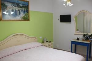 una camera da letto con un letto e un dipinto sul muro di Villa Lucia B&B a Tortoreto