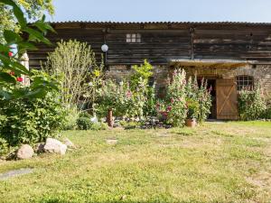 an old barn with flowers in front of a yard at Apartment Amylee in Strehlow