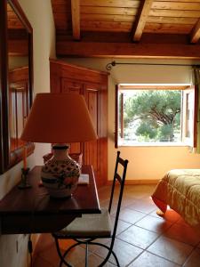 a lamp on a table in a bedroom with a window at Villa Paladino Solunto in Santa Flavia