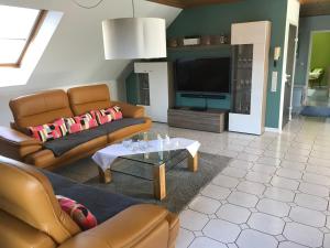 a living room with two couches and a tv at Ferienwohnung Zimmermann in Birkenfeld