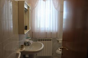 Elle comprend une petite salle de bains pourvue d'un lavabo et d'une fenêtre. dans l'établissement Villa Lucia B&B, à Tortoreto Lido