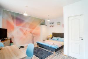 a bedroom with a bed with a colorful wall at Galeria Grafit Apartments in Sibiu