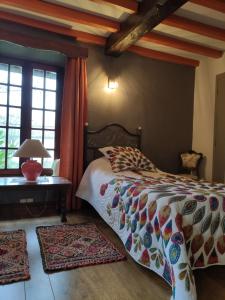 een slaapkamer met een bed en een tafel en ramen bij La Commanderie in Loison-sur-Créquoise