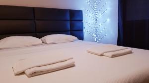 Monte Liza في دوبرا فودا: سرير أبيض مع منشفتين مطويتين عليه