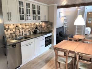 uma cozinha com armários brancos e uma mesa de madeira em Fogelbergs RyG em Visby
