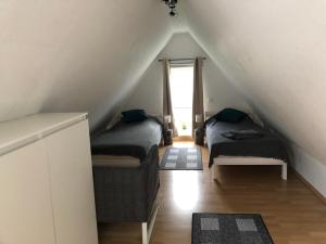 a attic room with two beds and a window at Gästehaus Kantelberg in Dahme