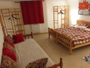 1 dormitorio con 2 camas y cortina roja en Appartement du lac, en Guillestre