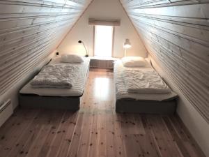 twee bedden in een kleine kamer met een raam bij Fogelbergs RyG in Visby
