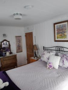 a bedroom with a large white bed with pillows at Maison des lilas in La Malbaie