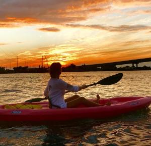 a child in a kayak on the water at sunset at Inn on Turner in Oriental +38 photos