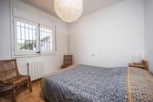een slaapkamer met een bed, een stoel en een raam bij Jolie Villa vue mer - 100km au Nord de Barcelone - in Pals