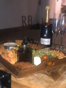 una mesa con una botella de vino y una bandeja de comida en Rosie's Barn en Penrith