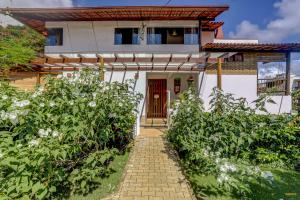 a house with a pathway leading to the front door at Pousada Residenzial Cariocare in Itacaré