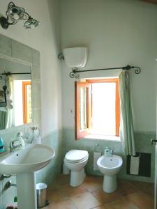 a bathroom with a sink and a toilet and a window at Villa Paladino Solunto in Santa Flavia