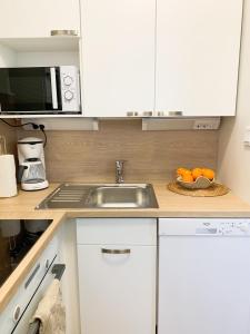 La cuisine est équipée d'un évier et d'un four micro-ondes. dans l'établissement Cityview Design Apartment Amber, à Lahti