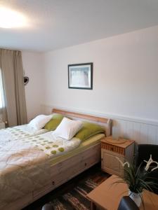 a bedroom with a bed and a table and a chair at Pension Mien Fründt in Baabe