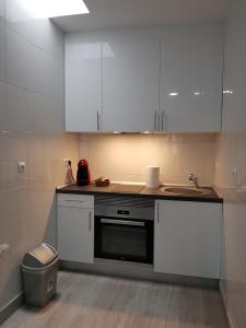 a kitchen with white cabinets and a sink at A casa de Mateo in Ribadavia +4 photos