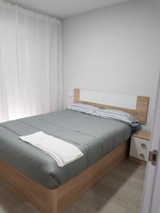 um quarto com uma cama com uma estrutura em madeira em A casa de Mateo em Ribadavia