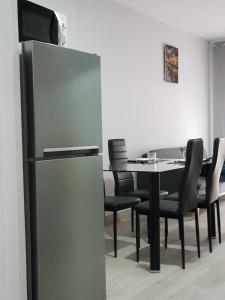 uma sala de jantar com uma mesa e um frigorífico em A casa de Mateo em Ribadavia