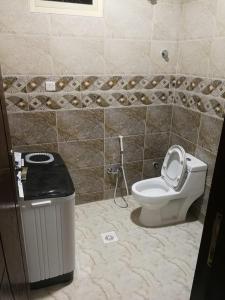 baño con aseo y cubo de basura en روز للوحدات السكنيه, en Al Thybiyah