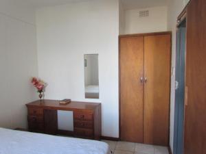 a bedroom with a dresser and a wooden cabinet at 704 Suidkus Rivera in Port Shepstone