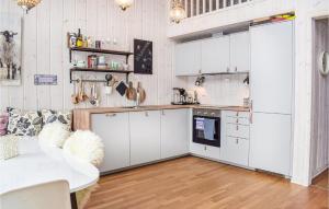 a kitchen with white cabinets and a table at Amazing Home In Sjusjen With 4 Bedrooms And Wifi in Sjusjøen