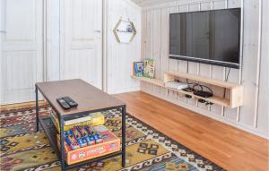 un salon avec une table et une télévision dans l'établissement Gorgeous Home In Sjusjen With House A Mountain View, à Sjusjøen