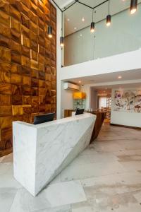 a lobby with a marble counter and a stone wall at FCH Hotel Providencia in Guadalajara