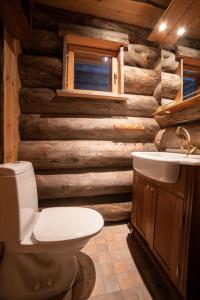 a bathroom with a toilet and a wooden wall at Rukan Villa Nuotta in Ruka
