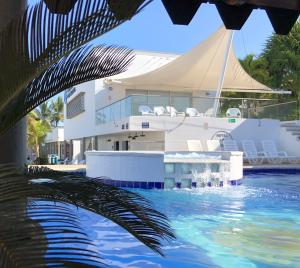 a boat in the water with a palm tree at Hotel La Fragata in Coveñas