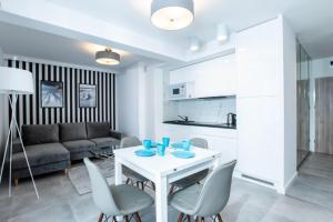 里沃的住宿－Resort Apartamenty Klifowa Rewal 30，厨房以及带桌椅的起居室。