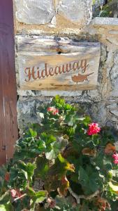 a sign on a stone wall with flowers at HideAway Lasa in Lasa