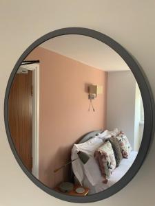 a mirror in a room with a bed with pillows at The Firs at Hay-on-Wye B&B in Hay-on-Wye