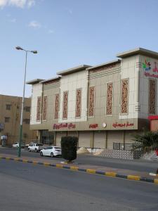 un edificio en una calle con coches aparcados delante en روز للوحدات السكنيه, en Al Thybiyah