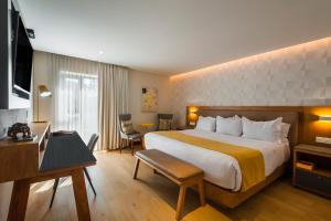 a hotel room with a large bed and a desk at FCH Hotel Providencia in Guadalajara