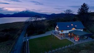uma vista aérea de uma casa com uma montanha em Knockderry Lodge -Private Luxury pet-friendly accommodation in Scotland with hot tub em Cove