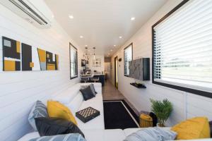 a living room with a white couch and a window at The Zephyr Modern Luxe Container Home in Bellmead
