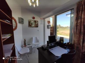 una oficina con escritorio, ordenador y ventana en Kostas Apartments, en Kourouta