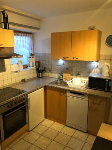 a kitchen with wooden cabinets and a sink at Ferienwohnung Aretsried in Fischach