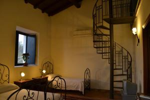 a room with a spiral staircase and a bed at Intero alloggio - Casale a Sant'Alfio immerso nel verde in SantʼAlfio