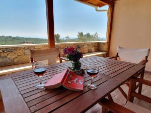 a wooden table with two glasses of red wine at Stoupa Lefktro 9 in Kalamata