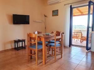 a dining room with a table and chairs and a television at Stoupa Lefktro 10 in Levktron
